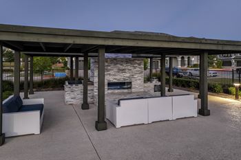 Trellis-covered outdoor kitchen & conversational fireplace lounge